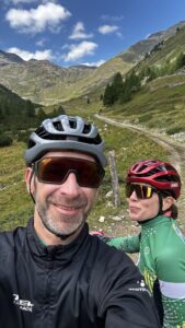 Kolarze na trasie w Livigno jadą do granicy ze Szwajcarią - piękny widok na Alpy w Livigno