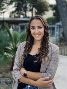 psycholożka sportowa Kinga Legieta stojąca na tle palm przygotowująca się do spotkania z zawodnikami